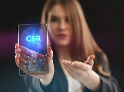 Frau zeigt fiktives Smartphone mit dem Displaytext "CSR"
